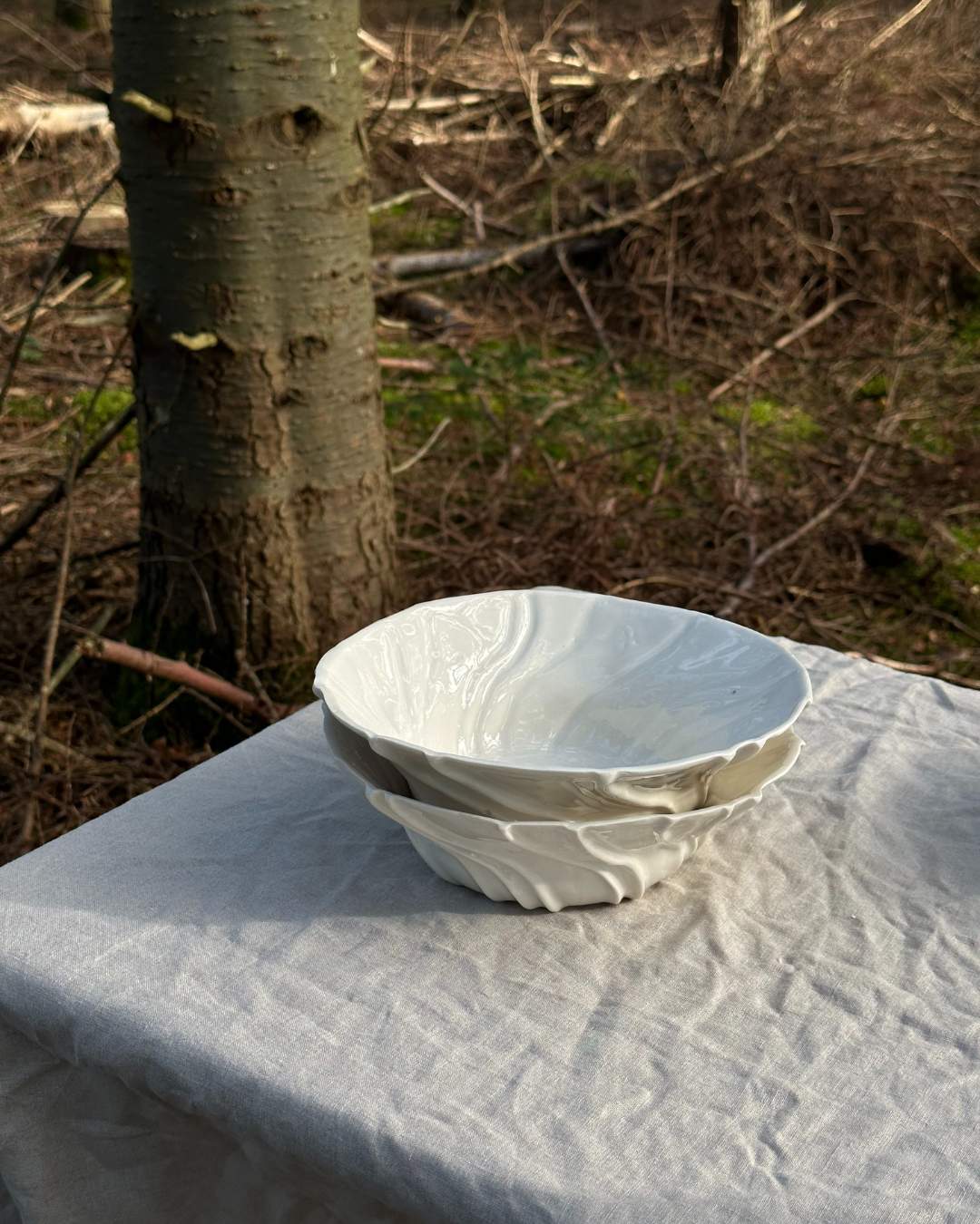Håndlavet tidevands skål i hvid porcelæn med bølgende overflade, inspireret af havbund.