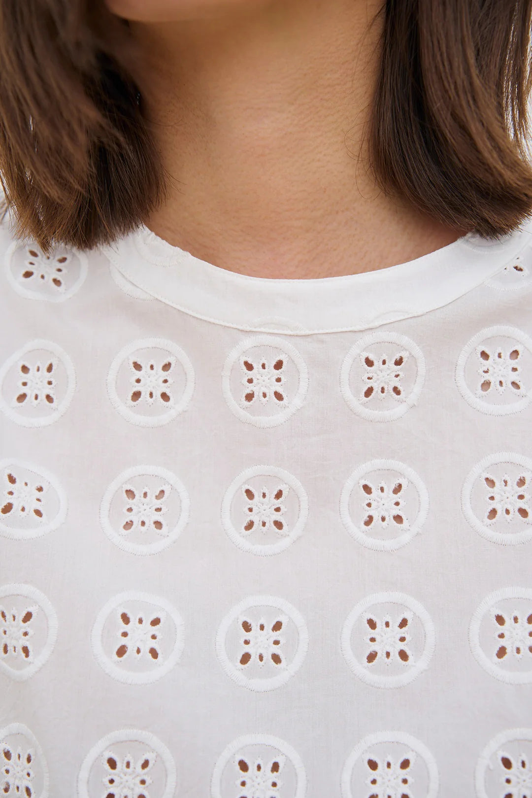 Klassisk top med rund hals og uden ærmer. Overdelen har det smukkeste broderi anglaise, som kan kombineres med nederdel i samme mønster.