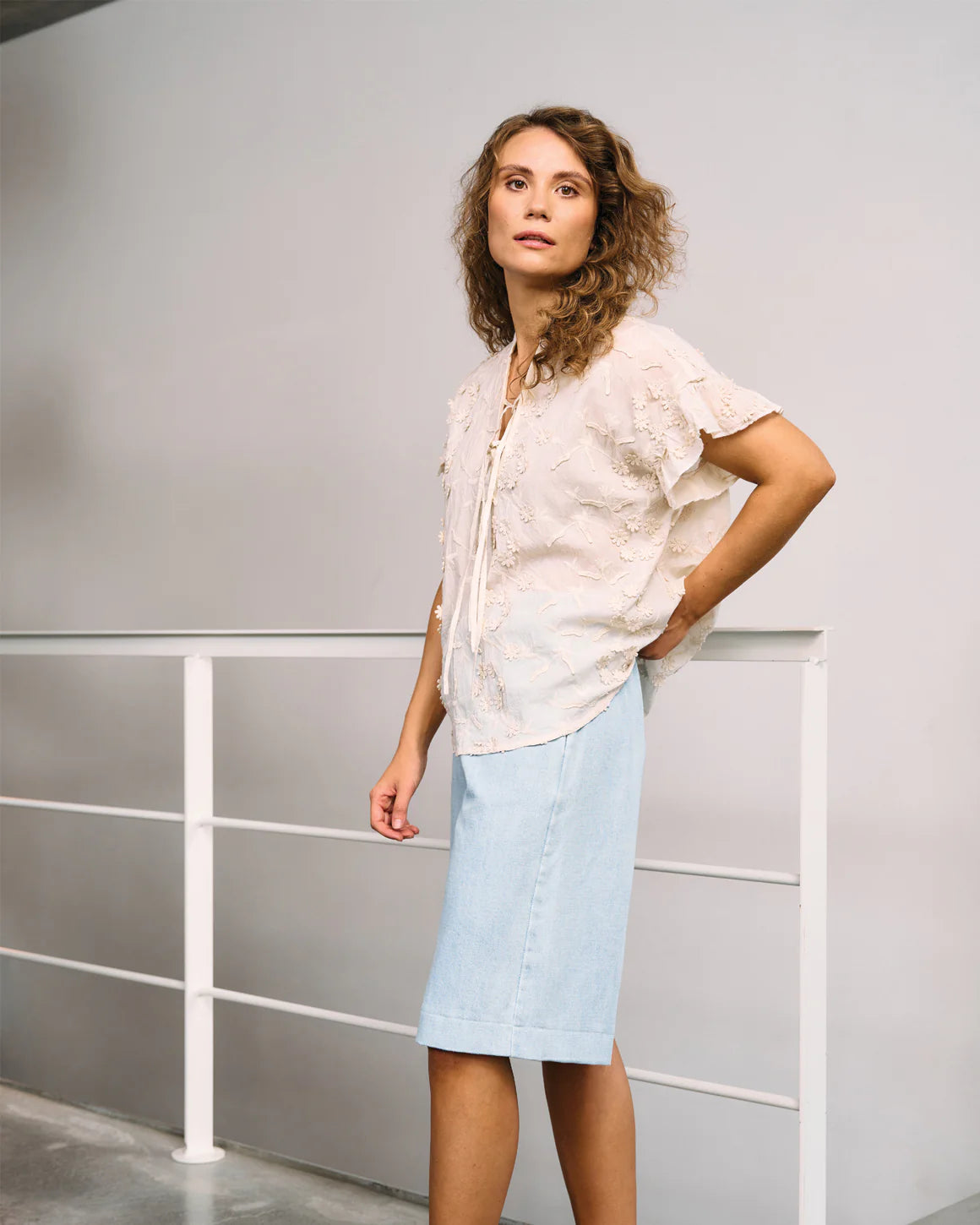 Model iført Britt Blouse – feminin sommerbluse med 3D-blomster og smalle stropper i 100% bomuld