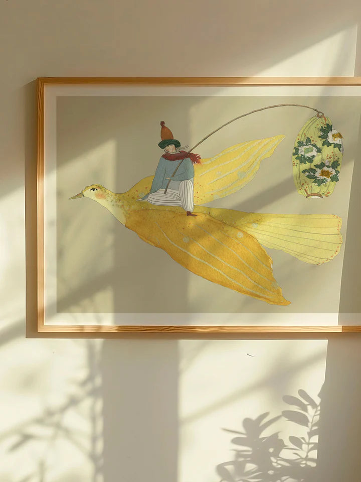 Lysfuglen fra Krull Studio i 230 gram mat kvalitetspapir. Motivet forestiller en gul fugl med en person ovenpå.