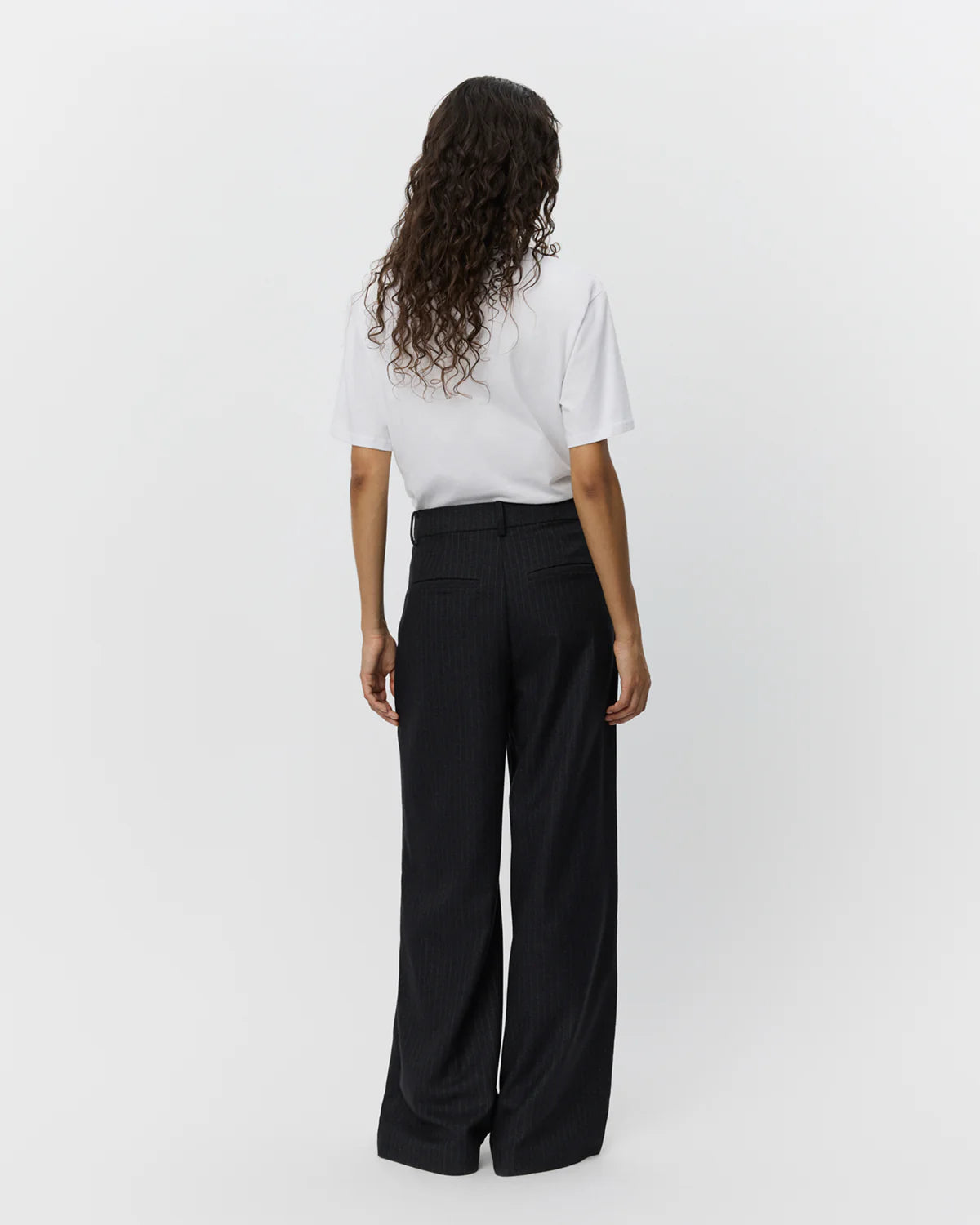 Sorte nålestribede wide leg-bukser fra Sofie Schnoor – med mid-waist, sidelommer og paspolerede snydelommer