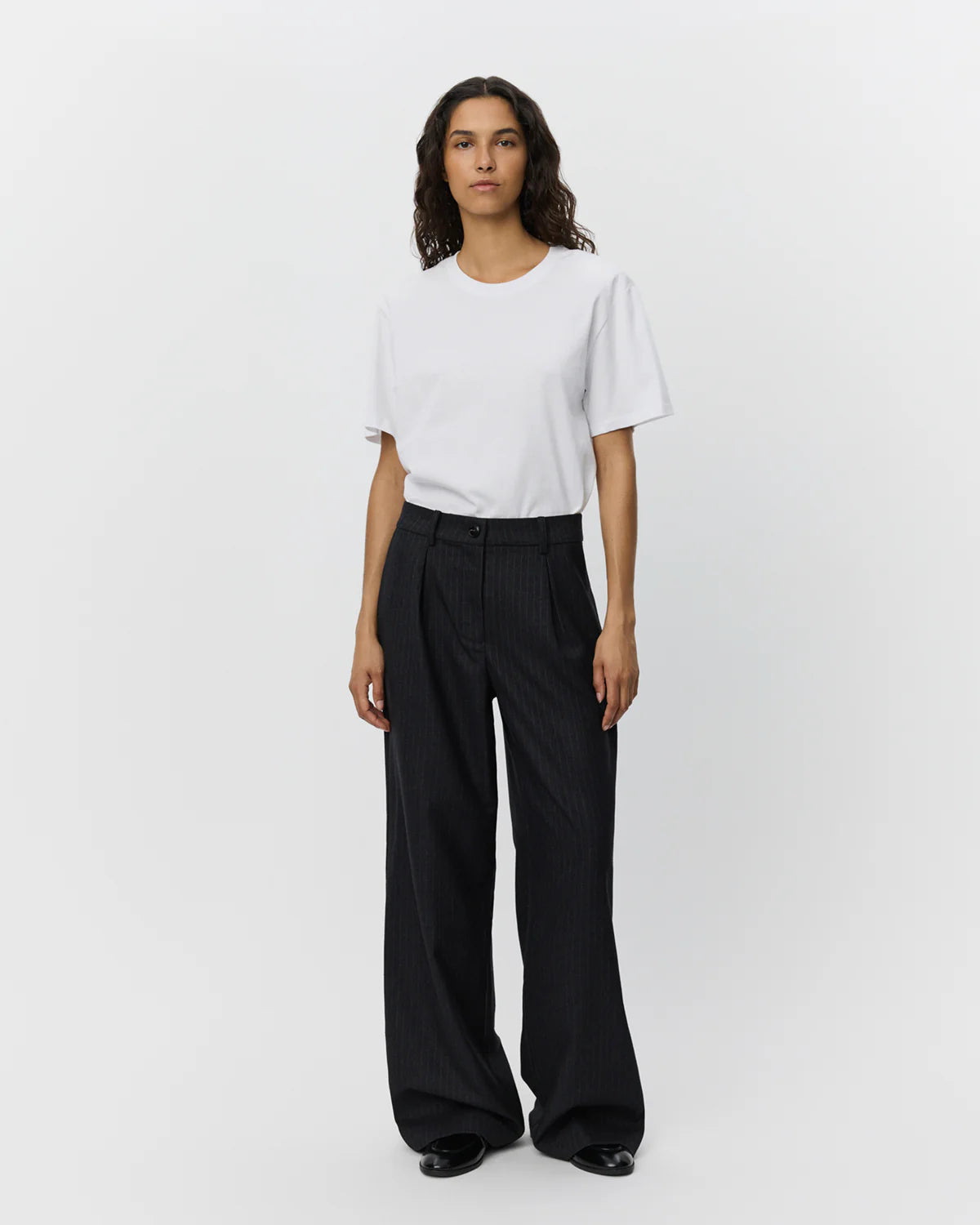 Sorte nålestribede wide leg-bukser fra Sofie Schnoor – med mid-waist, sidelommer og paspolerede snydelommer