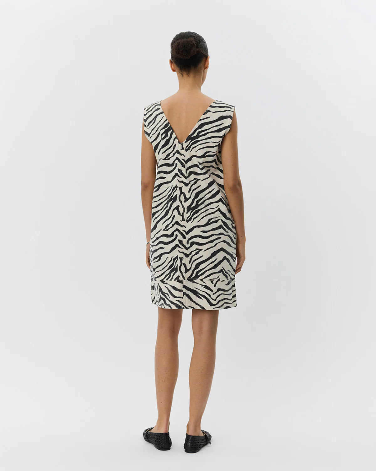 Mini kjole uden ærmer med zebraprint. Der er v-hals foran og bagpå, og det er en perfekt kjole til sommer, men kan også sagtens bruges om vinteren med lag-på-lag.