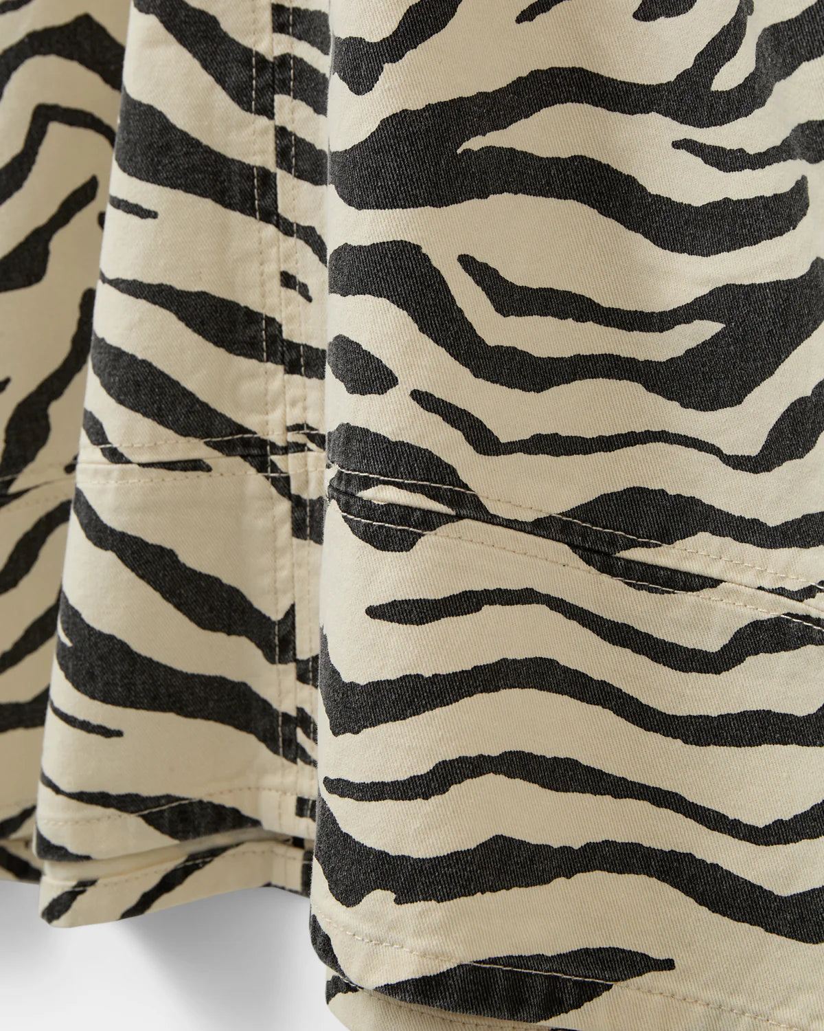 Mini kjole uden ærmer med zebraprint. Der er v-hals foran og bagpå, og det er en perfekt kjole til sommer, men kan også sagtens bruges om vinteren med lag-på-lag.