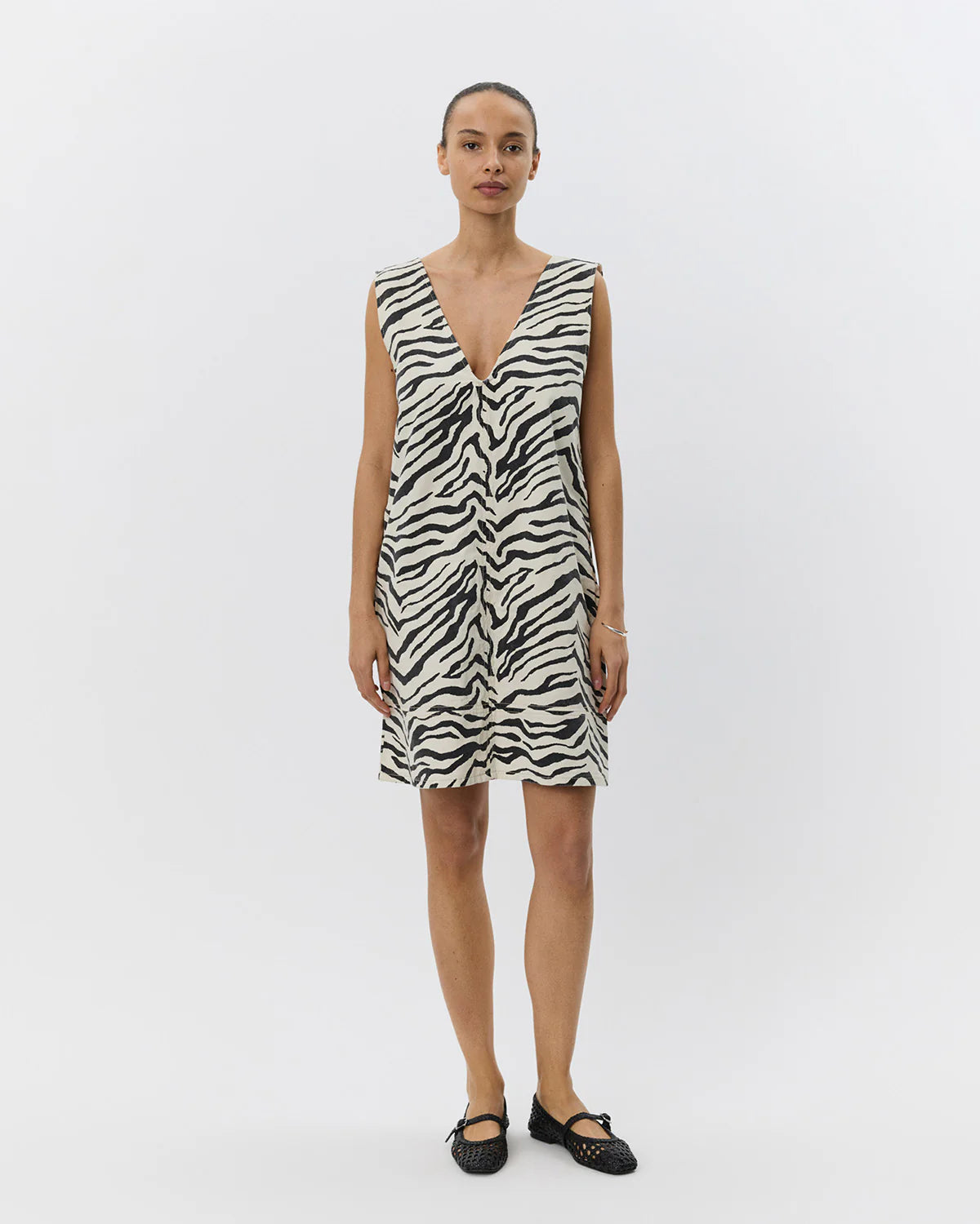 Mini kjole uden ærmer med zebraprint. Der er v-hals foran og bagpå, og det er en perfekt kjole til sommer, men kan også sagtens bruges om vinteren med lag-på-lag.