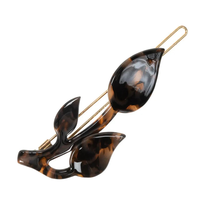 Hårklemme formet som et skud/blomst. Den er lavet af acetat og messing, og er sort/brun i farven LEO.