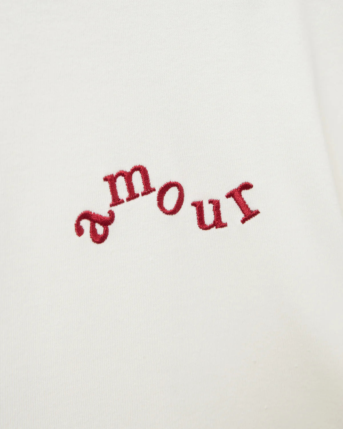 Hvid t-shirt med rund hals og afslappet look. Der er broderet 'amour' foran og så har overdelen et sødt budskab skrevet bagpå.