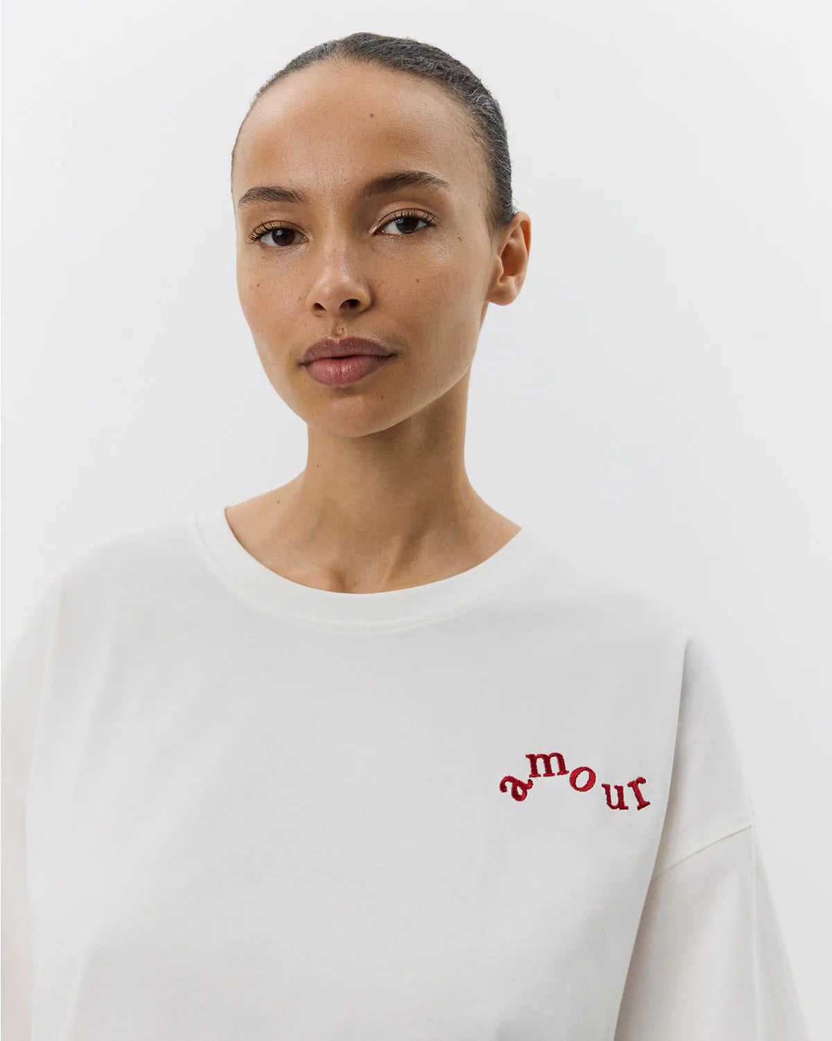 Hvid t-shirt med rund hals og afslappet look. Der er broderet 'amour' foran og så har overdelen et sødt budskab skrevet bagpå.