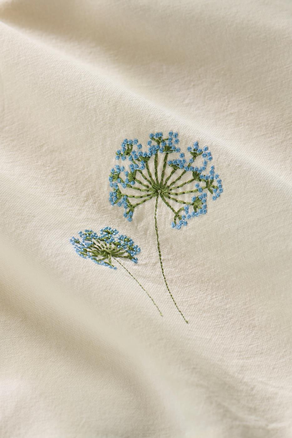 Viskestykke Flora 50x70 cm i butter cream med blå skærmblomst – køb hos butikalrum.dk