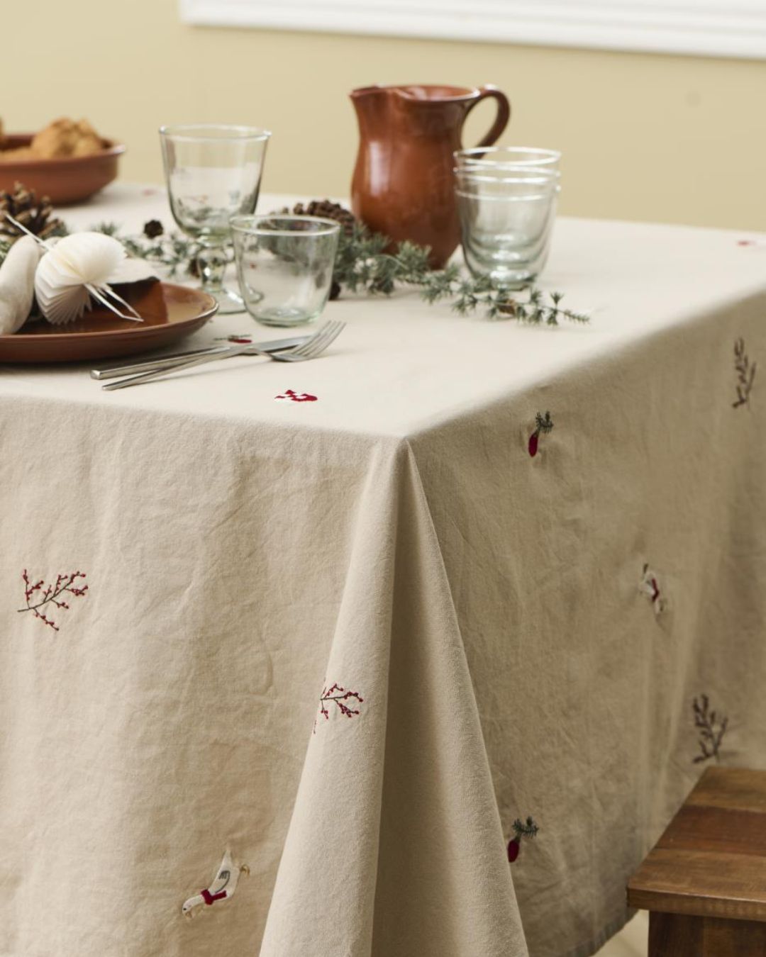 Juledug med broderede julemotiver på hørfarvet baggrund.