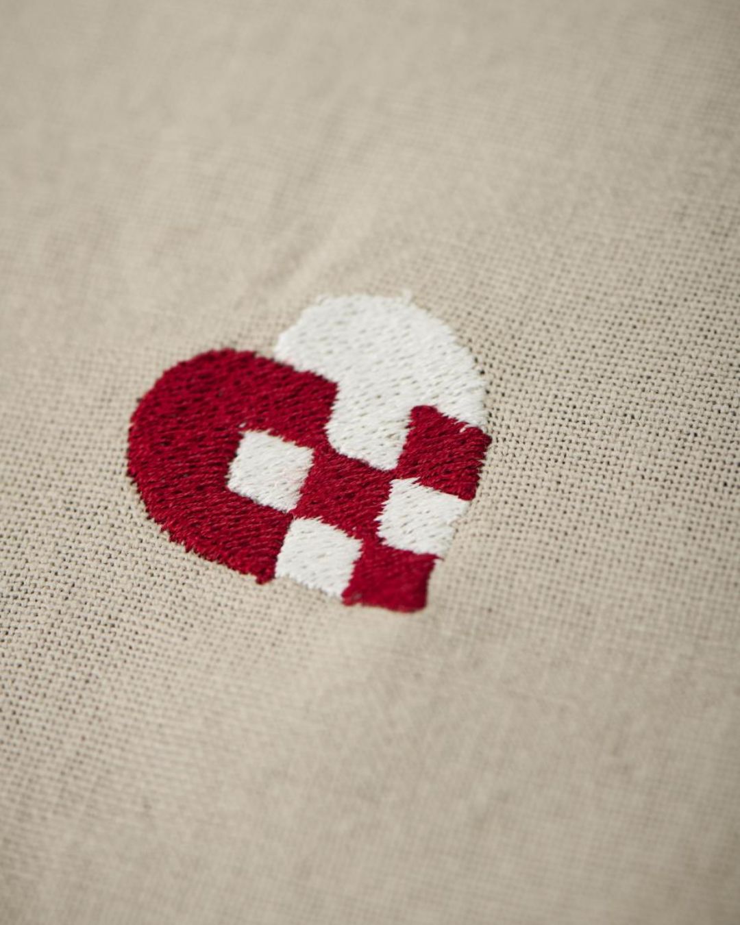 Juledug med broderede julemotiver på hørfarvet baggrund.