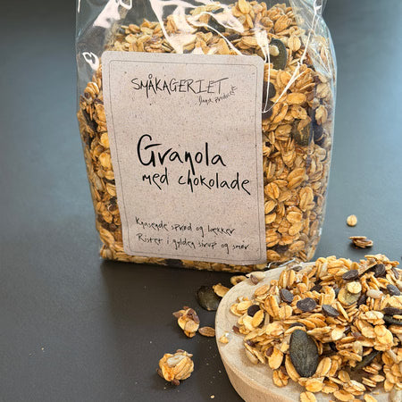 Granola Chokolade fra Småkageriet med sprøde havreflager, ristede kerner og mørk chokolade – en lækker topping til yoghurt og skyr – køb hos butikalrum.dk.