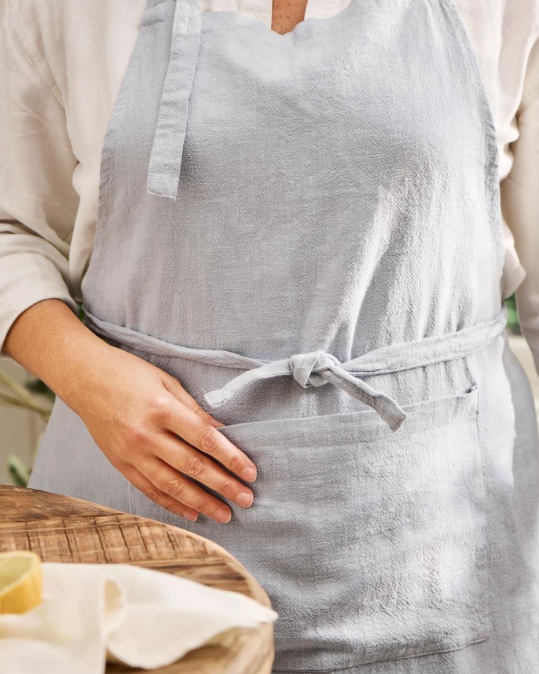Lyseblåt forklæde med lomme – praktisk og stilfuldt design, ideelt til madlavning og bagning.