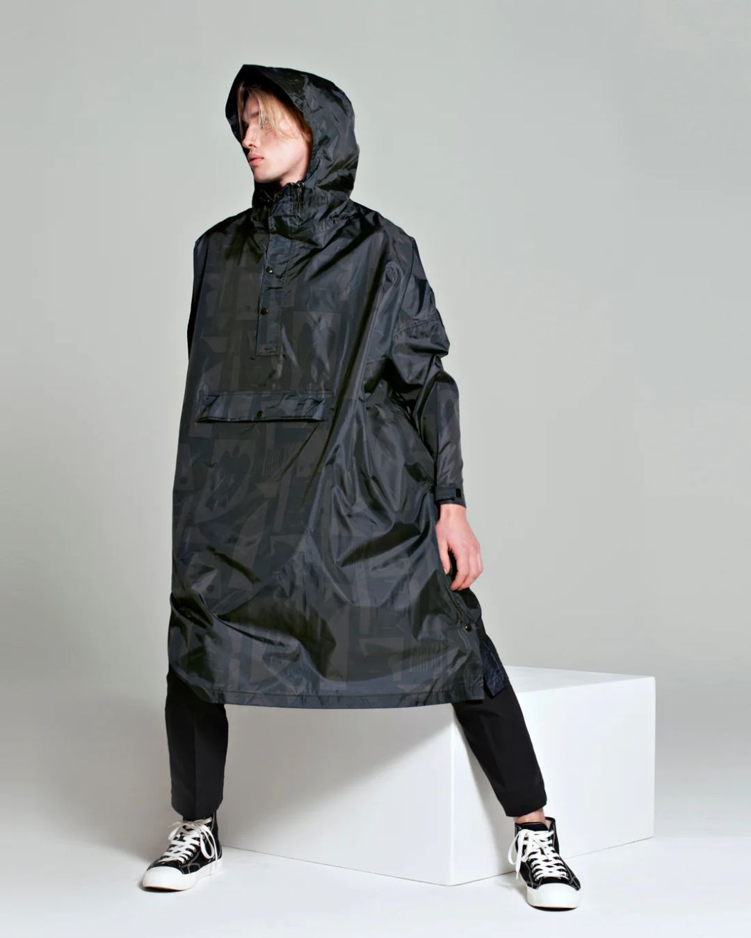 Rainkiss Poncho i back to black art camo – vandtæt og cykelvenlig unisex-regnponcho med ekstra længde, der holder lårene tørre i regnvejr.