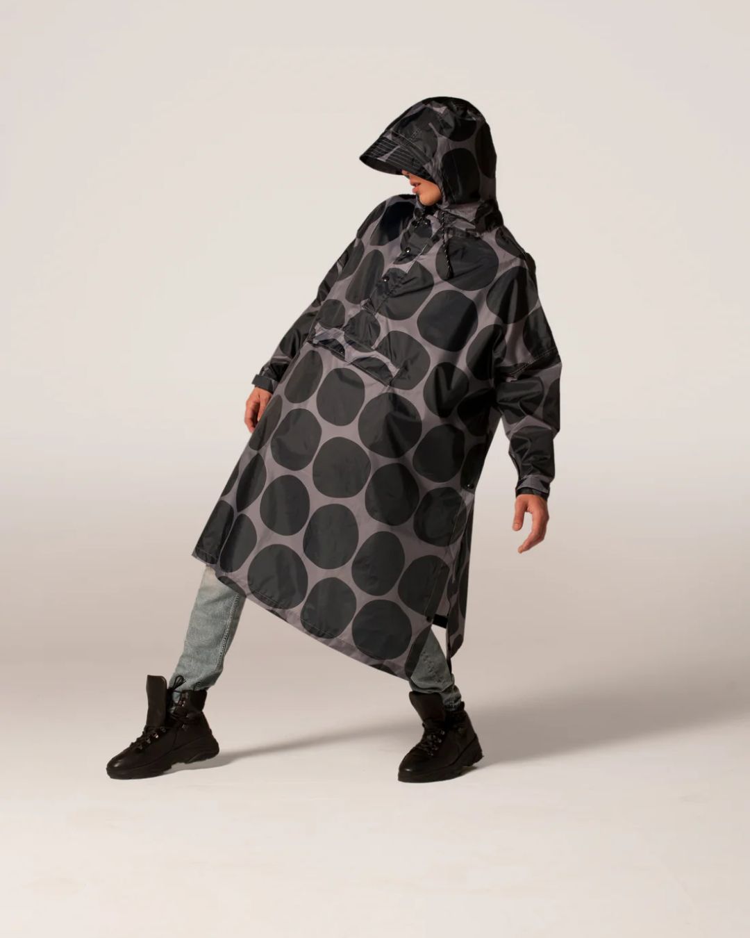 Rainkiss Poncho i Black Polka – vandtæt og cykelvenlig unisex-regnponcho med ekstra længde, der holder lårene tørre i regnvejr.