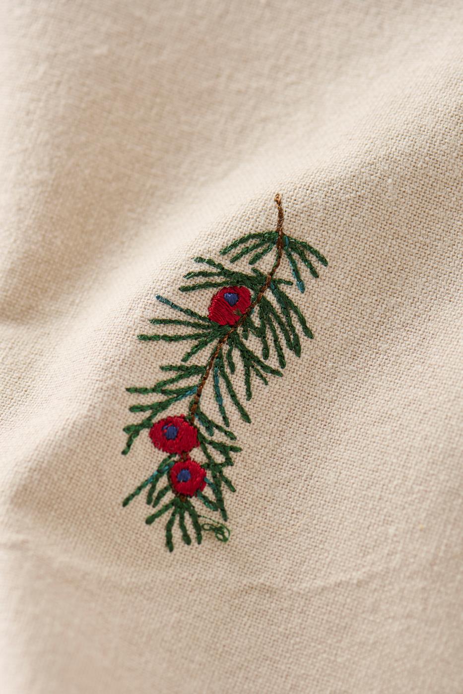 Hørfarvet stofserviet Tradition i vasket bomuld med broderet gren og røde bær – køb hos butikalrum.dk.