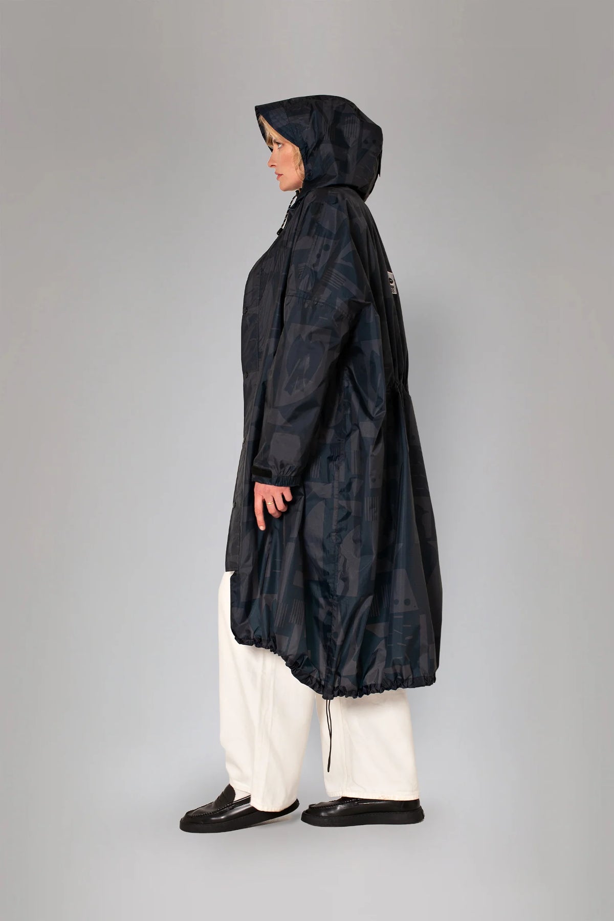 Rainkiss Raincoat i Back to Black med ton-i-ton print, oversized pasform og 100% vandtæt genanvendt polyester – køb hos butikalrum.dk.