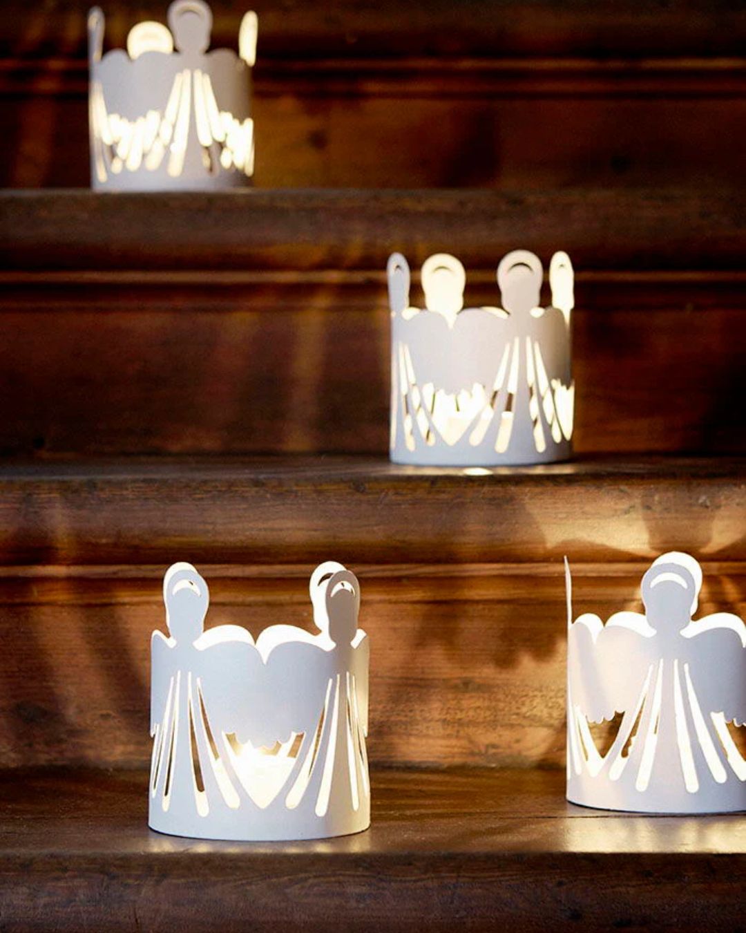 Elegant fyrfadsstage med hvidt englemotiv, lavet af malet metal.