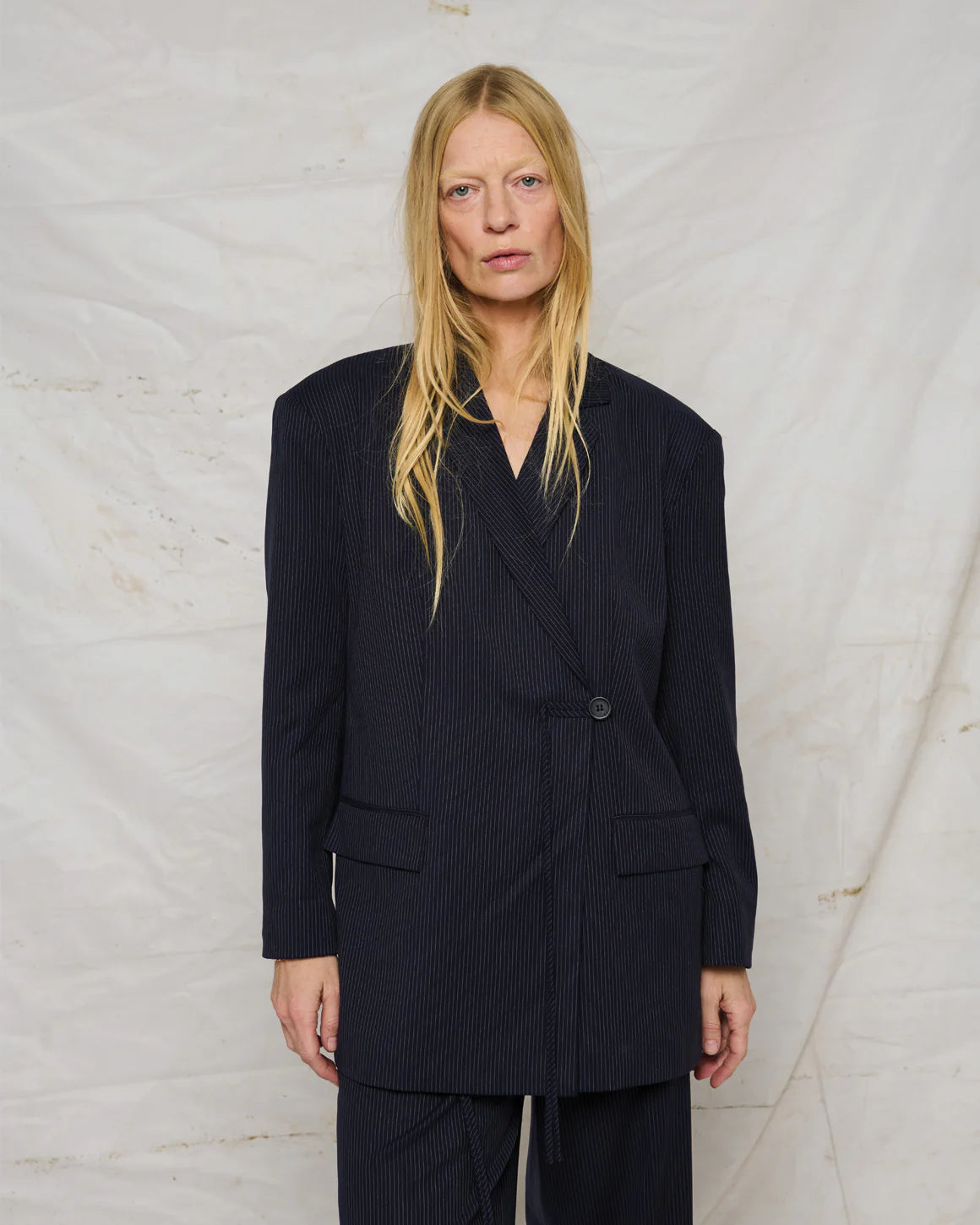 Catrine Blazer – nålestribet oversized blazer med klassisk revers, knaplukning og snordetalje.