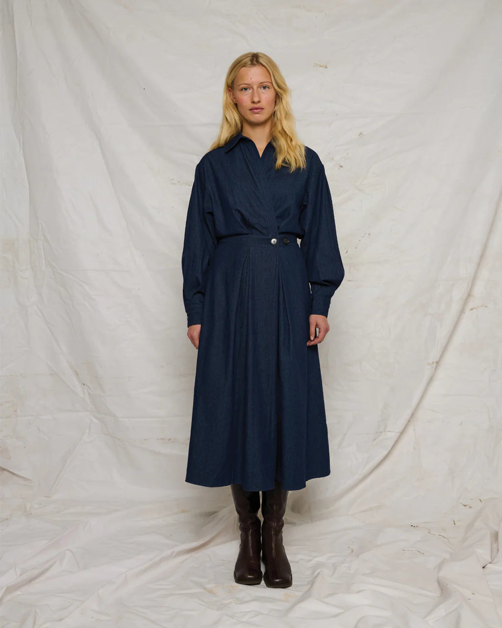Charlotte Dress – langærmet skjortekjole i mørk marine denim med v-hals, markeret talje og knapdetalje i siden.