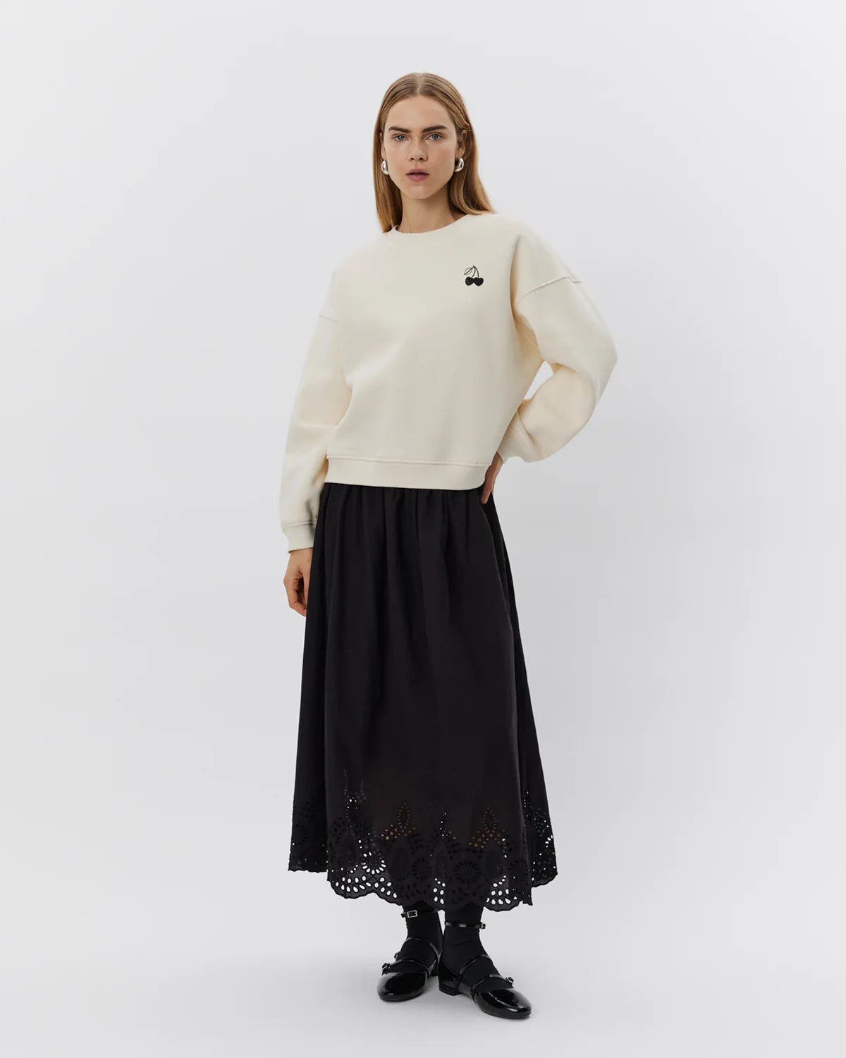 Off white sweatshirt med sort kirsebærmotiv på brystet, tekstprint på ryggen og brede ribkanter.