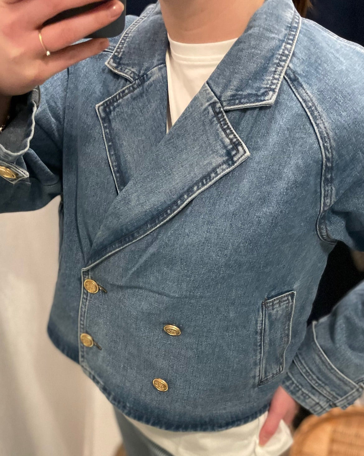 Lyseblå denimjakke med dobbeltknaplukning, klassisk revers, forlommer og cropped, boxy snit.