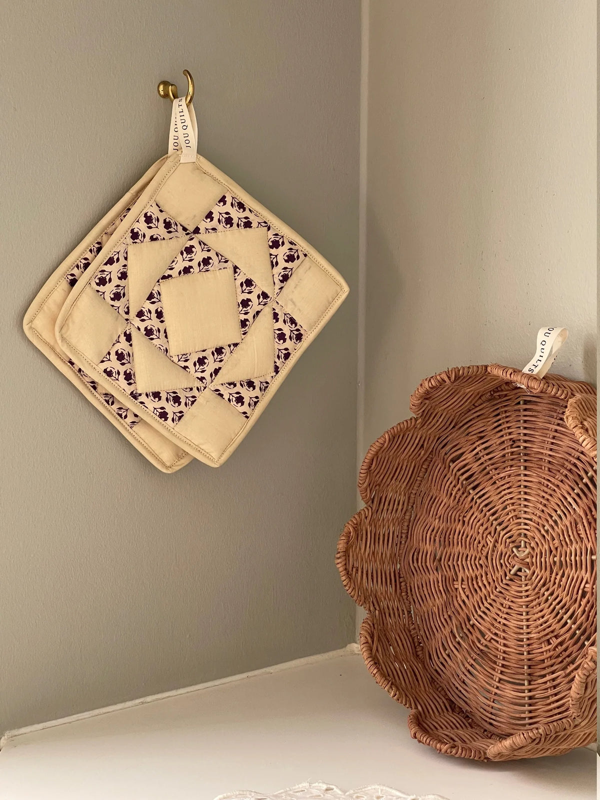 JOU Patchwork grydelapper 2 stk. i creme og mørk aubergine, håndsyet i 100% bomuld, 20x20 cm – køb hos butikalrum.dk.