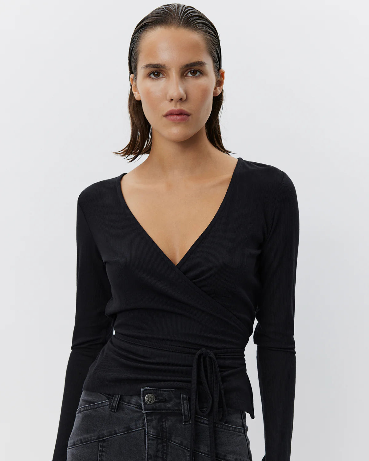 JOODYSW wrap-bluse med lange ærmer i sort, ribstruktureret materiale og V-hals fra Sofie Schnoor