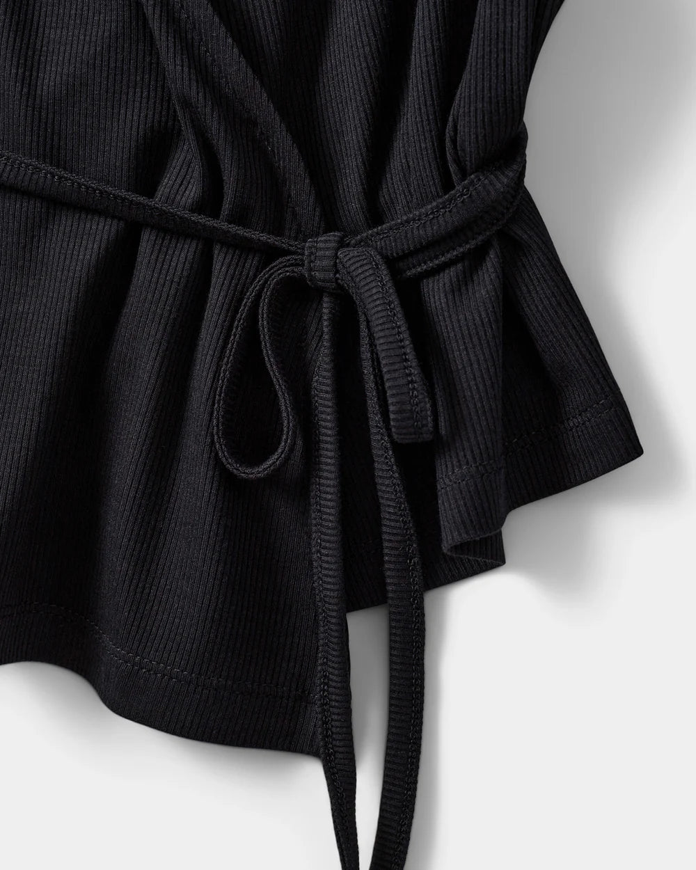 JOODYSW wrap-bluse med lange ærmer i sort, ribstruktureret materiale og V-hals fra Sofie Schnoor