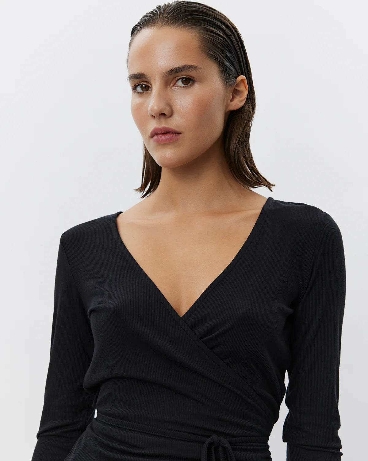 JOODYSW wrap-bluse med lange ærmer i sort, ribstruktureret materiale og V-hals fra Sofie Schnoor