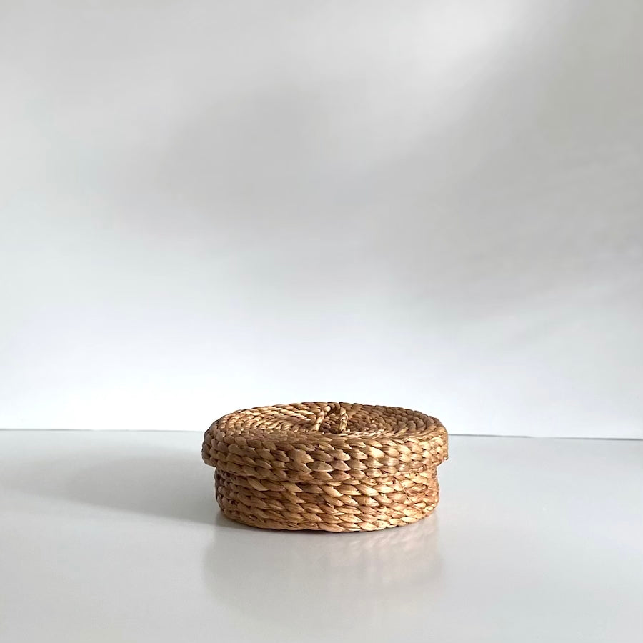 Wave kurveæske med låg i naturfarvet vandhyacint, Ø30 cm – håndflettet på Bali, ideel til dekorativ opbevaring.


