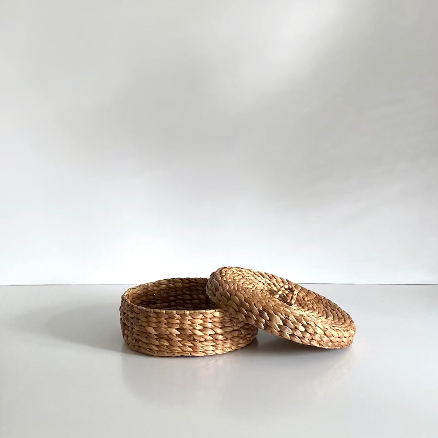 Wave kurveæske med låg i naturfarvet vandhyacint, Ø30 cm – håndflettet på Bali, ideel til dekorativ opbevaring.


