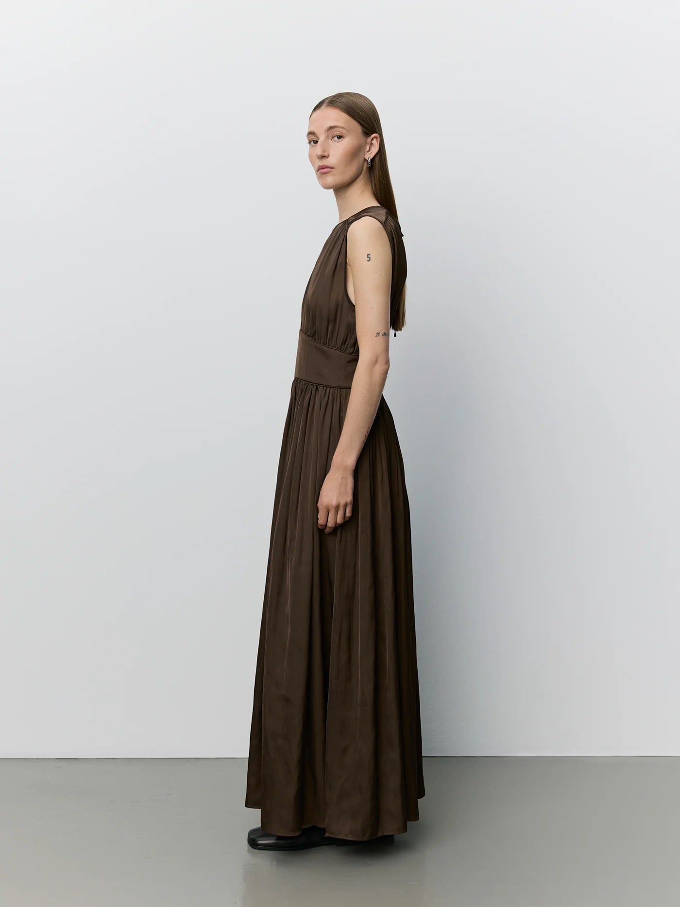 LINSW maxi kjole fra Sofie Schnoor i Intense Brown med markeret talje og lang silhuet – køb hos butikalrum.dk.