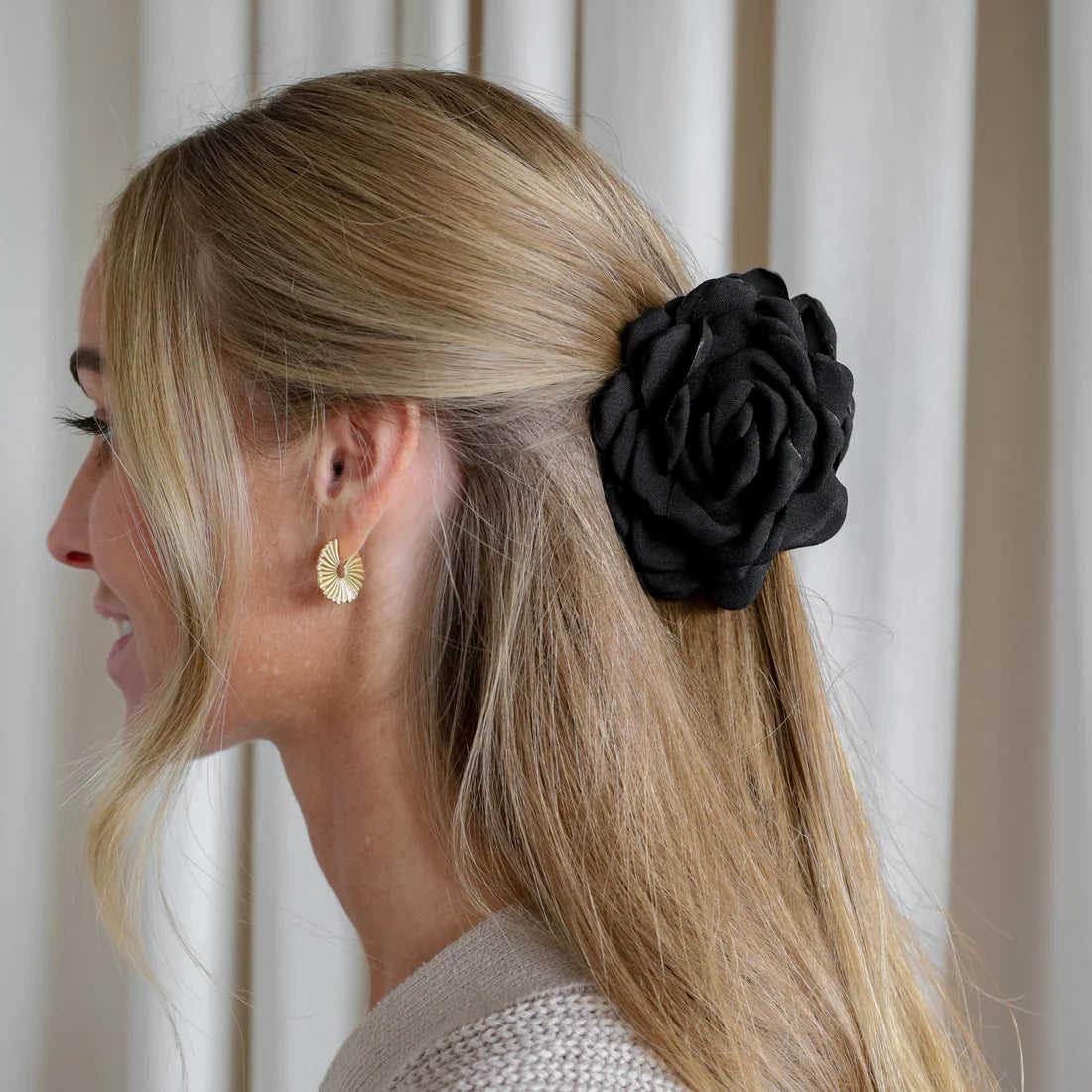 Lille sort Daisy hårklemme formet som en blomst – fås hos Butik Alrum på Amager.