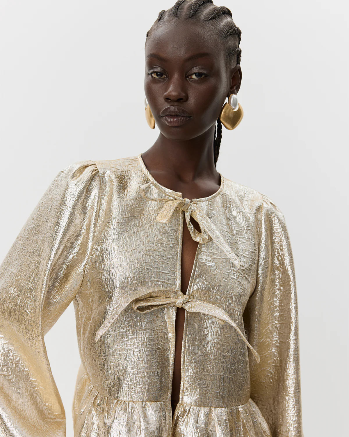 Let skinnende guldfarvet skjorte med peplum og bindebånd – fås hos butikalrum.dk