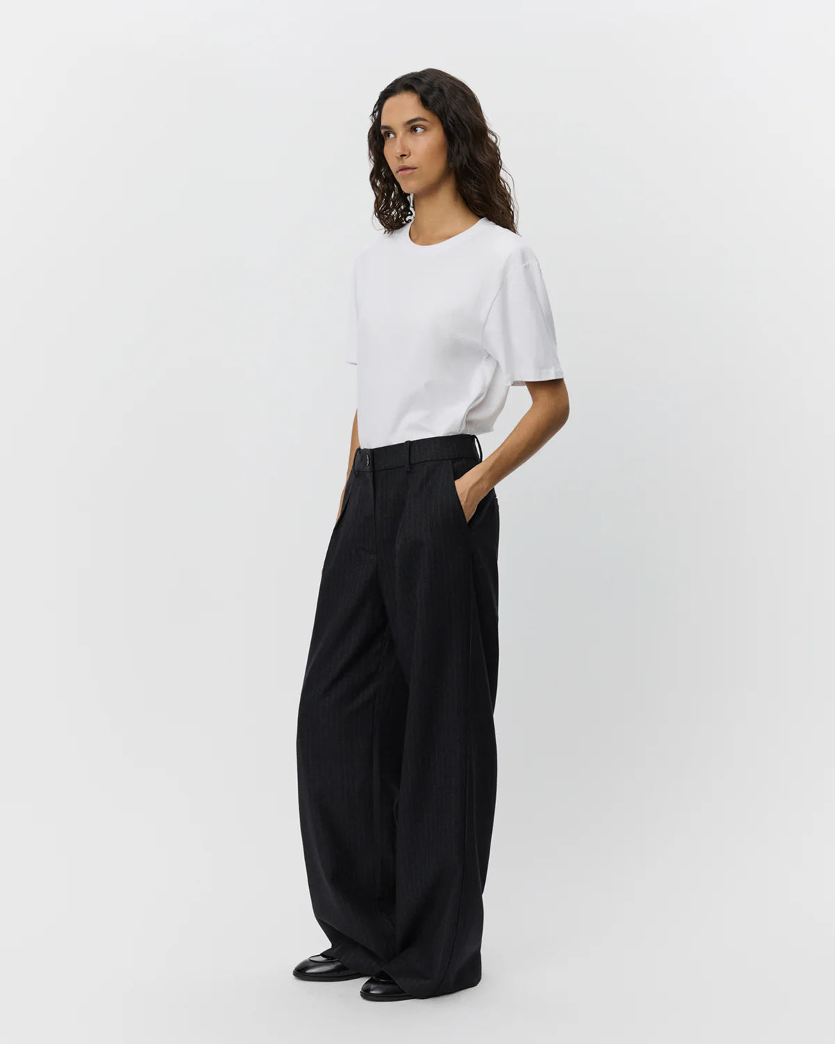 Sorte nålestribede wide leg-bukser fra Sofie Schnoor – med mid-waist, sidelommer og paspolerede snydelommer