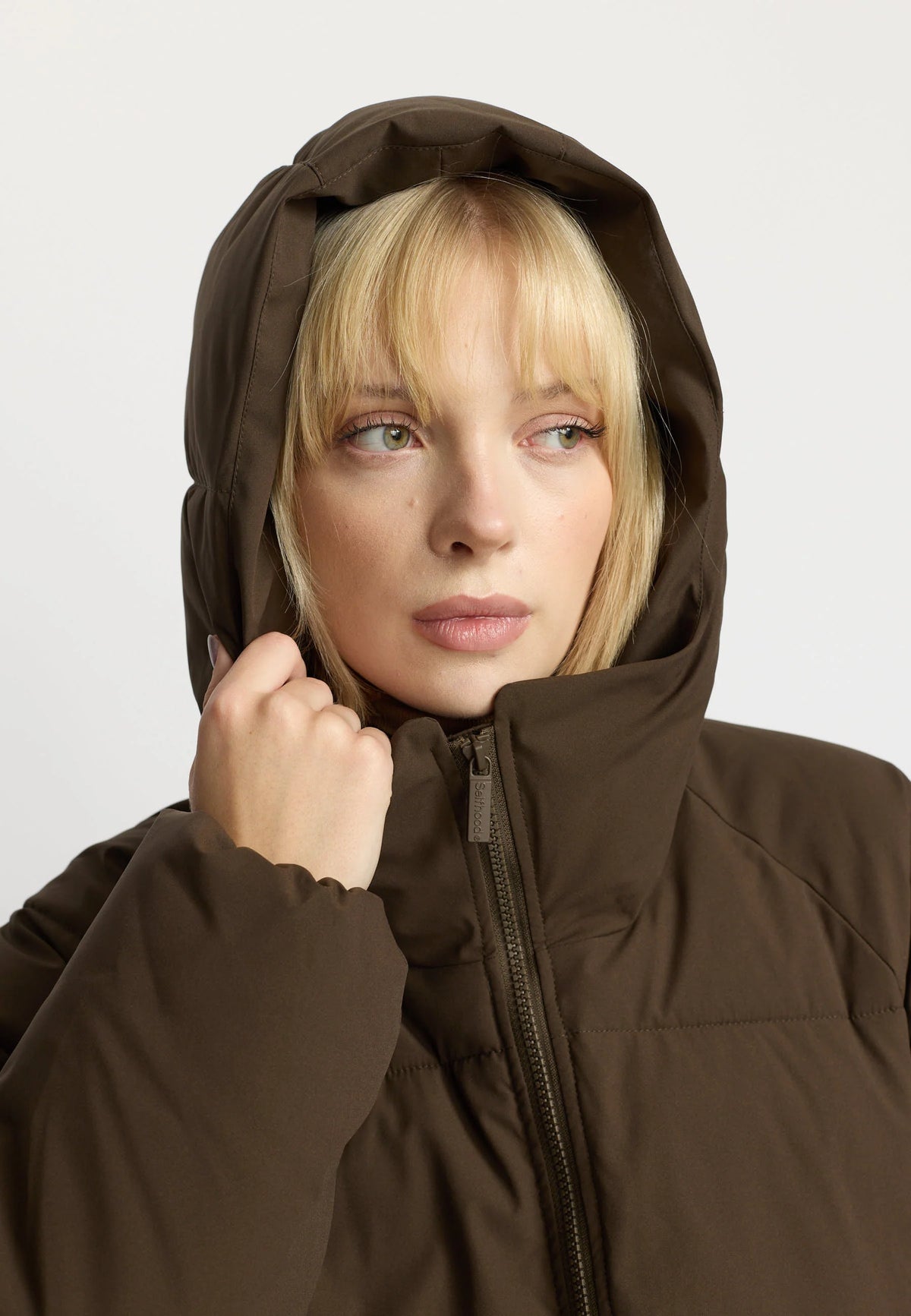 Oversize Puffer fra Selfhood i Darkbrown med hætte, Sorona® Padding og vandafvisende Teflon EcoElite-belægning – køb hos butikalrum.dk.