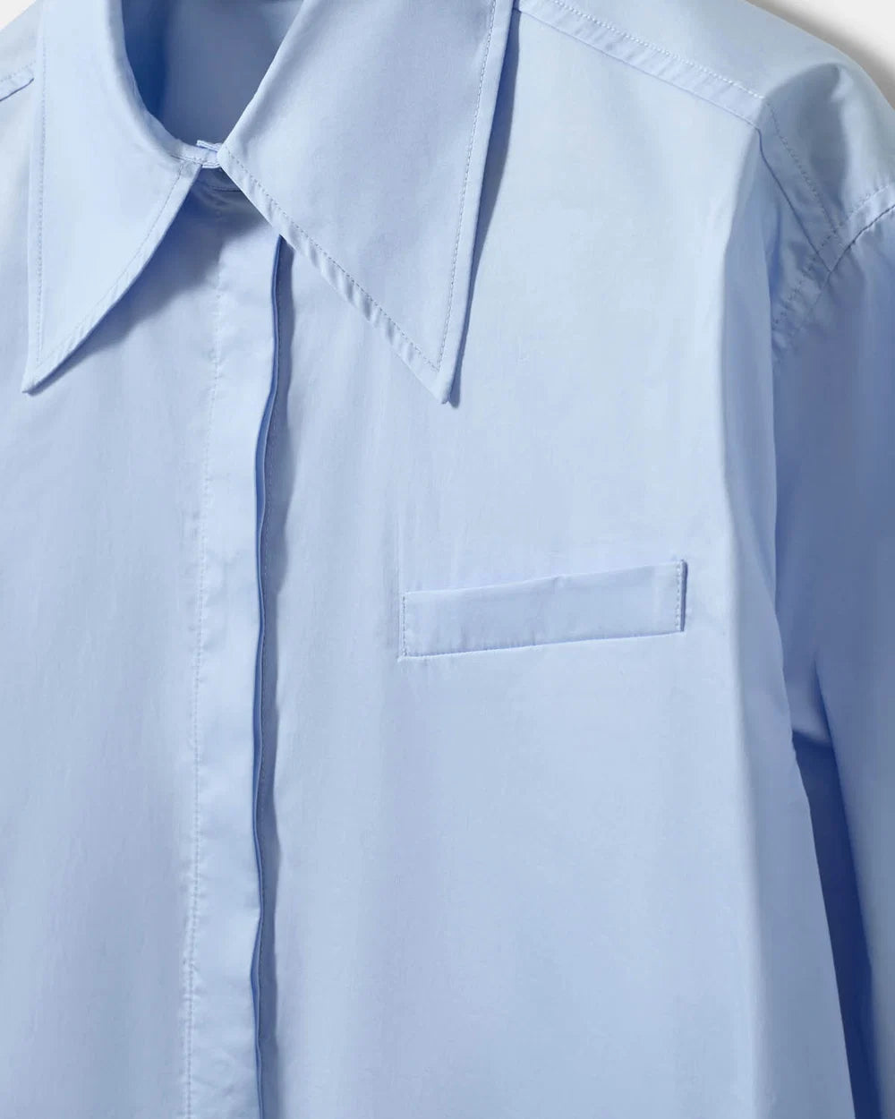PERLASW oversized poplin skjorte fra Sofie Schnoor i Light Blue med spids krave og skjult knaplukning – køb hos butikalrum.dk.
