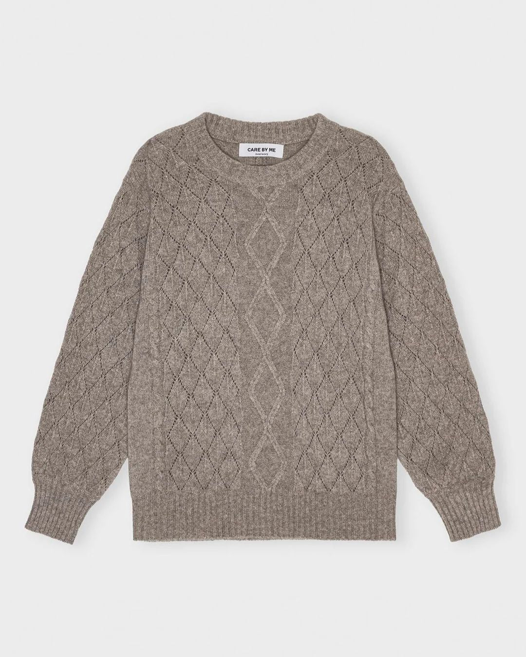 Blød og elegant cashmere striktrøje i sandfarve fra Care By Me – klassisk kabelstrik med rund hals og raglanærmer.