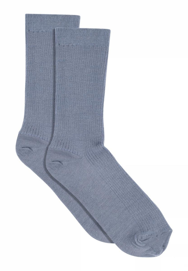Fine Wool Rib Socks i Stone Blue, ribstrikkede uldstrømper med mellemlangt skaft og klassisk struktur – køb hos butikalrum.dk.