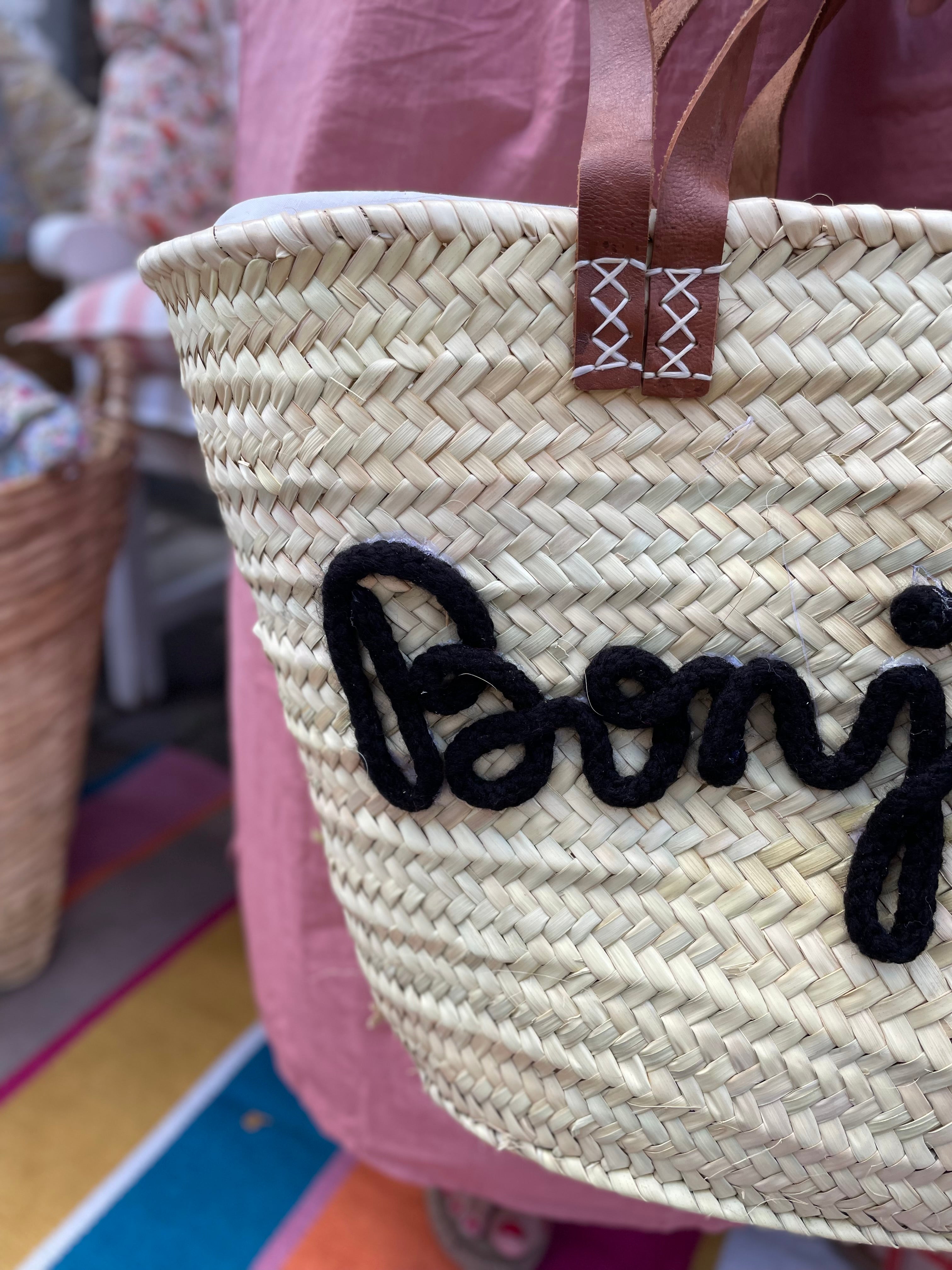 Stor flettaske med brune hanke, sort Bonjour tekst og praktisk lukkepose indeni – køb hos Butik Alrum på Amager eller online på butikalrum.dk.