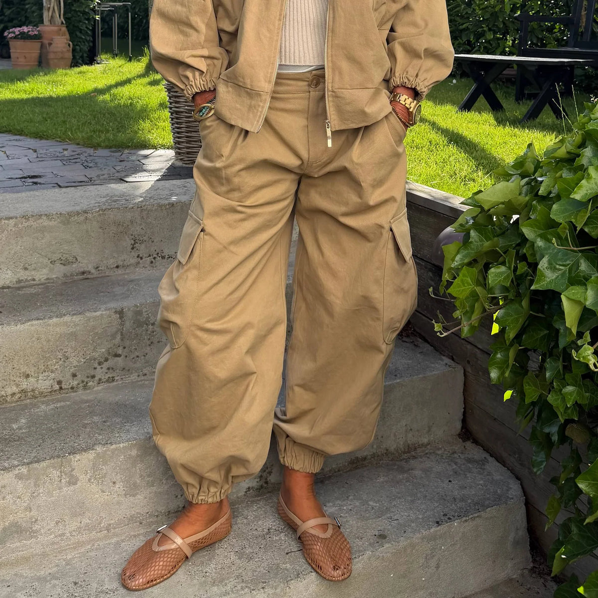 Nomade cargo bukser i Camello fra Cabana Living med loose fit, cargolommer og ballonpasform i 100% bomuld – køb hos butikalrum.dk.