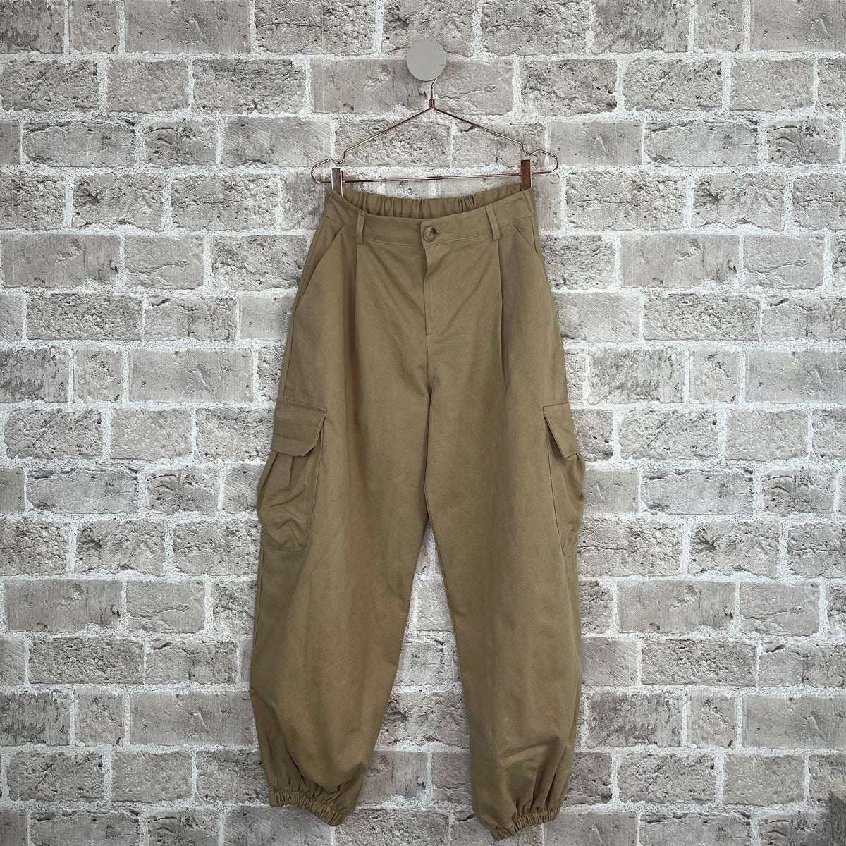 Nomade cargo bukser i Camello fra Cabana Living med loose fit, cargolommer og ballonpasform i 100% bomuld – køb hos butikalrum.dk.