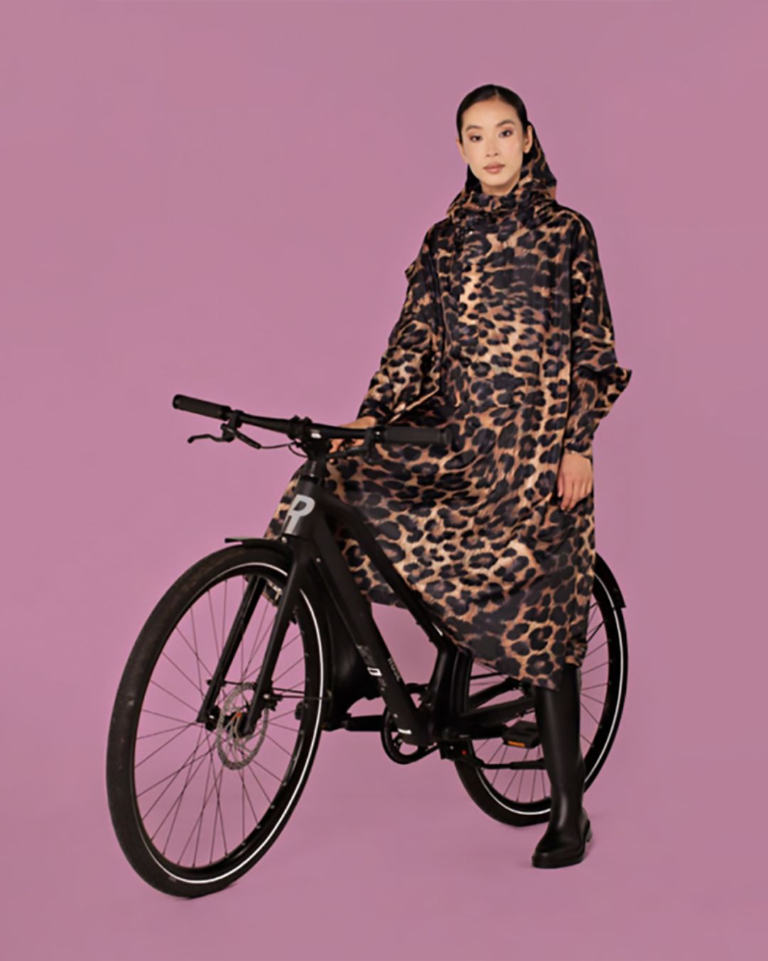 Rainkiss Poncho i Dark Leopard – vandtæt og cykelvenlig unisex-regnponcho med ekstra længde, der holder lårene tørre i regnvejr.