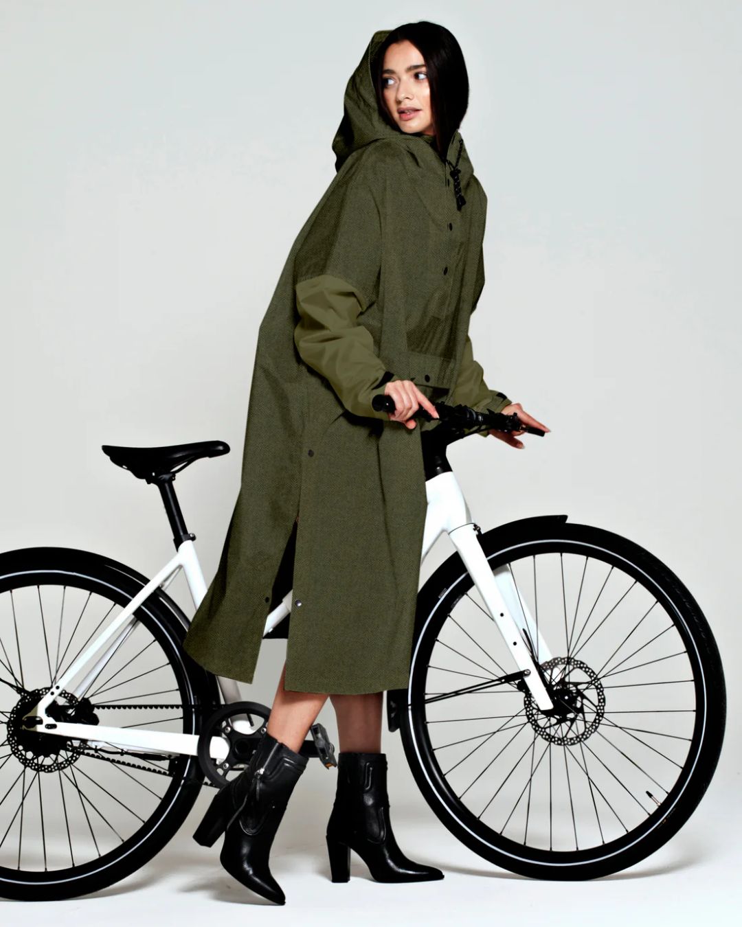 Rainkiss Poncho i Herringbone Green – vandtæt og cykelvenligt design med ekstra længde, der holder lårene tørre i regnvejr.