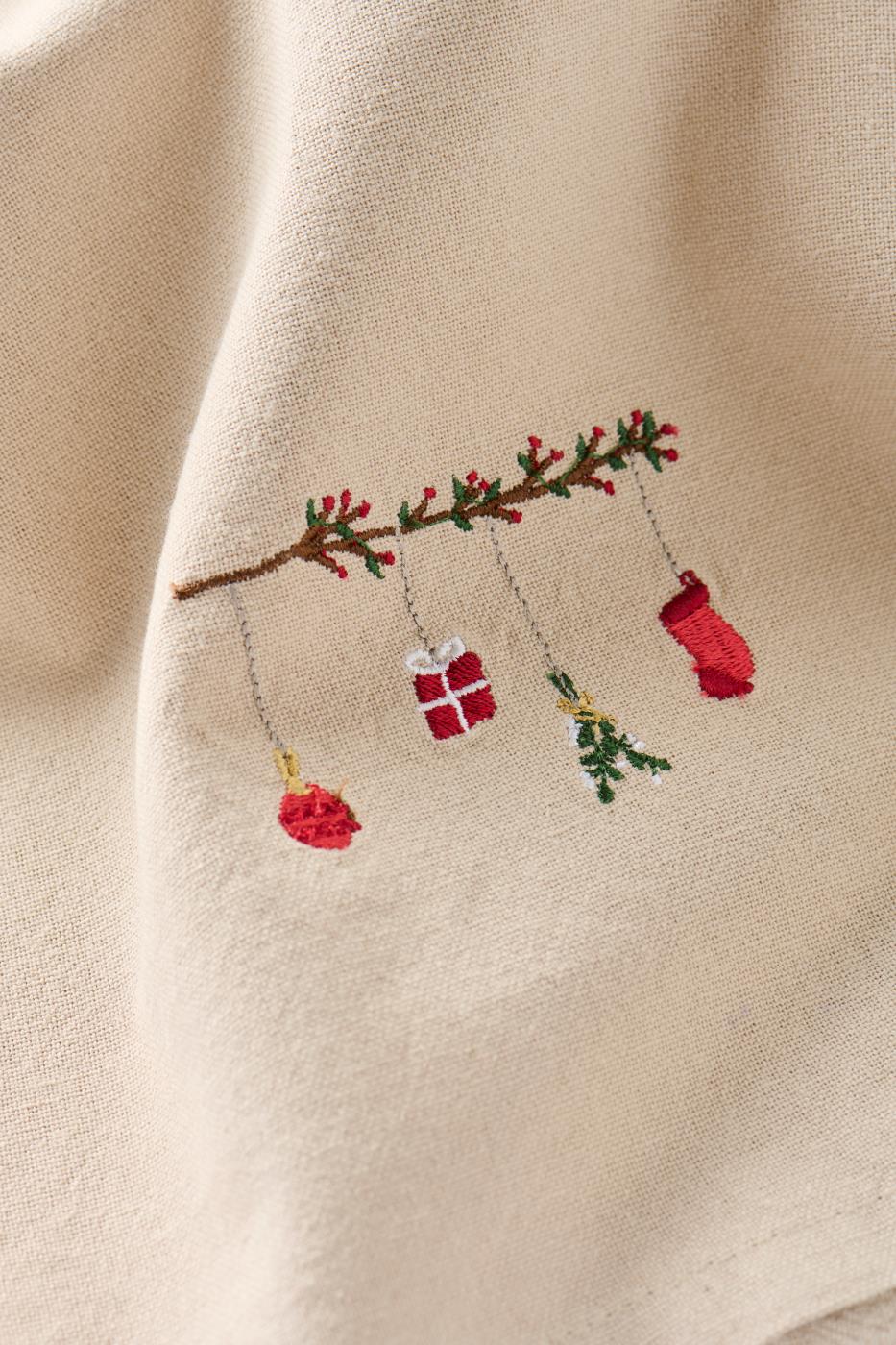 Hørfarvet stofserviet Tradition med broderet gren, røde bær og hængende julepynt – køb hos butikalrum.dk.